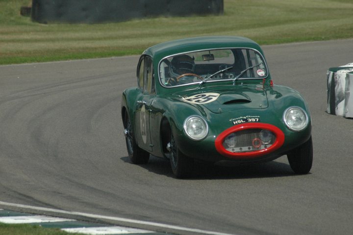 A car that is sitting in the street - Pistonheads - The image captures a classic runabout from the 1940s, painted in a vibrant green. The car's grille, headlights, and front bumper all feature a bold red color, adding a striking contrast to its bodywork. The car is in motion, swiftly navigating a turn on a track, with the driver inside, dressed in the period-appropriate attire. The background can be identified as a race track, identifiable by the blurred grassy area visible behind the car.