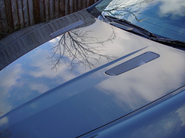 Early Morning Drive Sunday Pistonheads - The image captures a close-up view of a car's front end, focusing on the hood area. The hood of the car is reflecting a serene scene of a blue sky dotted with white clouds. The view is taken from the top of the car, providing a distinct perspective. Various car models have rhombus-shaped grilles, but the specific make and model are not discernible from this angle.