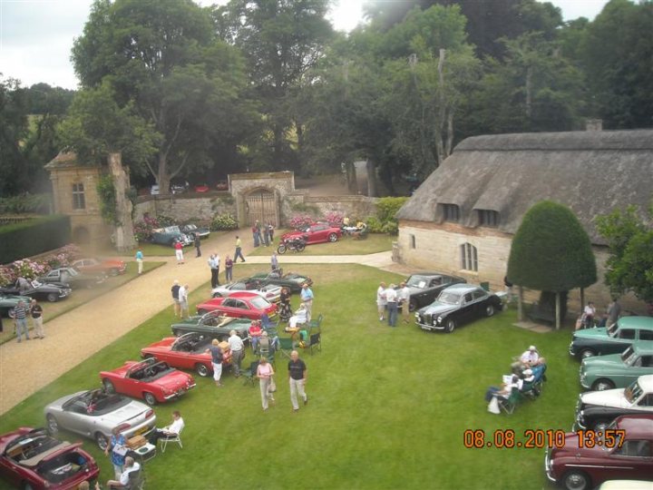 Pistonheads - The image depicts a classic car show held in a spacious, grassy field. Numerous vintage cars are on display, spread out across the lawn. The cars are a mix of hatchbacks, sedans, and coupes, each boasting distinct design elements. They are parked near what appears to be an English-style cottage, adding a picturesque backdrop to the event. Large trees surround the field, casting a canopy over the cars and providing shade for attendees. In the foreground, a group of spectators can be seen enjoying the car show and socializing in lawn chairs.

This classic car show captures the essence of vintage motoring, bringing together like-minded enthusiasts to appreciate the timeless beauty of these vehicles. The expansive green field provides a serene setting for the show, with trees framing the view and the nearby thatched cottage lending an air of rustic charm. The tightly-knit volleyball teams on this grassy area reflect the casual and relaxed atmosphere of the event. The image captures not only the vibrant hues of the classic cars but also the camaraderie and shared passion that make such gatherings so special.