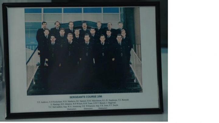 Line of Duty (BBC Police Drama) - Page 112 - TV, Film, Video Streaming & Radio - PistonHeads UK - This is a photograph of a framed picture placed on a flat surface. The framed photo depicts a group of individuals posing for a group portrait. They appear to be part of an organization or team, as suggested by the uniforms they are wearing and their formation in the image. The group consists of several men, all dressed in similar attire, which might indicate that they belong to the same organization or have similar roles within it.

The framed picture is set on a flat surface, possibly a table, and the photograph captures this moment with clarity. There's no text visible in the image. The background of the photo is simple and nondescript, focusing attention on the group portrait itself.