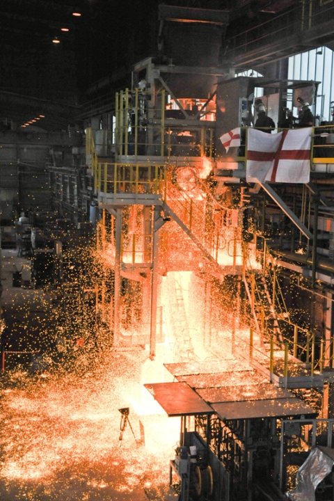 Pistonheads Btap Raffle Prizes - The image captures a scene inside a factory where a fire is burning fiercely. The fire is in the center of the frame, emitting bright orange and yellow flames that are quite intense. Above this intense fire, several factory workers can be seen, mostly positioned at the far right. They appear to be observing the situation or possibly even participating in efforts to extinguish the fire. The building structure and industrial setting in the background are made of metal and look sturdy and functional. The metal structures and the high-intensity fire suggest a manufacturing or industrial environment.