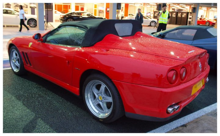 A red car is parked in a parking lot - Pistonheads