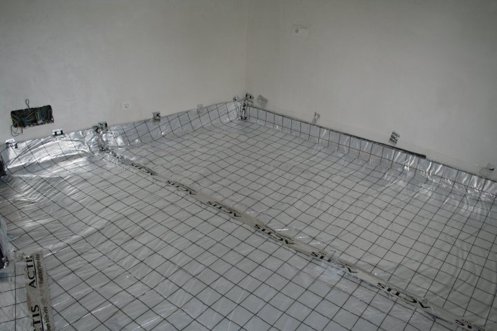 Pistonheads - The image shows an unfinished basement or construction site floor covered with a silver-colored material, likely a protective covering. The floor is marked with dark lines, possibly indicating a planned layout or design.