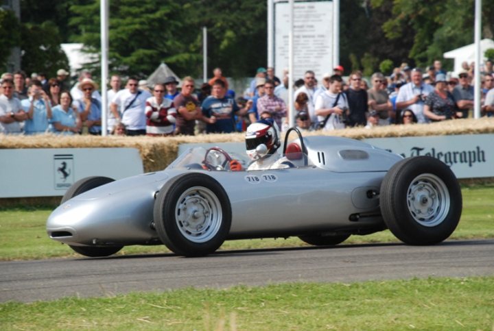 Pistonheads - The image captures an exciting scene from a car race. A silver, wing-shaped race car, labeled with the number 117, is moving down a track. Spectators are gathered around the track, with some of them carrying backpacks. In the background, there are hay bales, possibly as a safety measure or as a part of the course design. All of this suggests that the photograph was taken during an outdoor racing event.