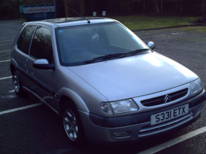 Turbo Impreza Pistonheads - In the image, a two-door silver hatchback car is parked in a lot. The car is the main focus of the image and is situated near a parking meter and a sign. The car's license plate reads "S33LETTX", suggesting it's registered in an area with a zone code starting with "S33". The background is blurred, but appears to be a parking space, indicating the car is parked legally. The image is detailed, capturing the car's gleaming silver exterior and its overall sleek design.