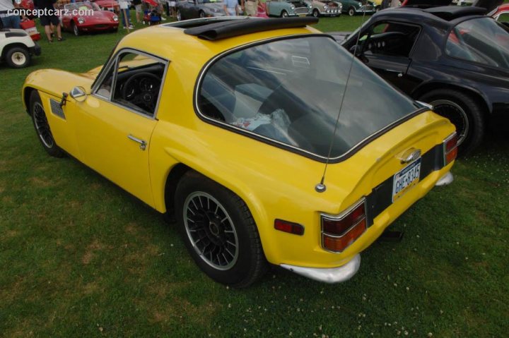 Early TVR Pictures - Page 73 - Classics - PistonHeads - This image showcases a vibrant yellow compact sports car parked on a lush grassy area. The car has a distinctive design, characterized by a large rear window and a small, round front window. The exterior of the car is adorned with black accents, adding to its sporty aesthetic. The vehicle is surrounded by a few other vehicles, suggesting it might be part of a community or exhibition. The overall setting appears to be a car show or a casual gathering of car enthusiasts.