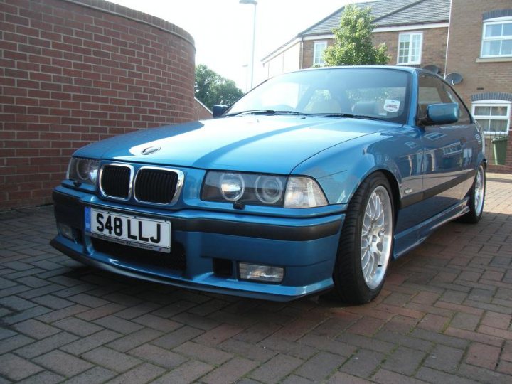 Pistonheads Individual Sport - The image shows a bright blue BMW car parked on a brick-patterned driveway. The vehicle is a coupe model with two doors, and it features a prominent front grille with the BMW roundel logo. The car is positioned at an angle, with its left side facing the camera. The license plate reads "S48 LLJ." The scene appears to be taken during the day in a suburban environment, with a house visible in the background. The car has a sleek design with alloy wheels, and the overall color contrasts with the earthy brick ground surface.