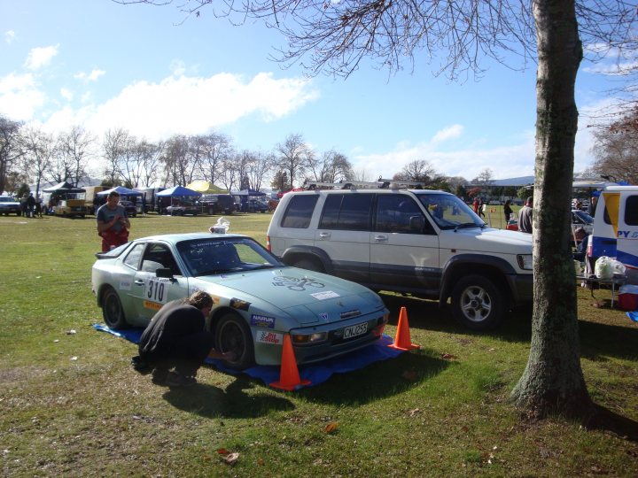 Show us your Daily driver, and Weekend Toy(s)!!! - Page 3 - Readers' Cars - PistonHeads - In the image, there's a vibrant scene in a grassy field where two cars are parked. The car on the left is a green sports car, while the car on the right is a white SUV. Interestingly, the sports car has a license plate that reads "311". The vehicles appear to be showcased on orange traffic cones. A person is seen crouching by the sports car, possibly inspecting or admiring the car. The backdrop features a clear blue sky and trees, adding to the pleasant atmosphere of the setting.