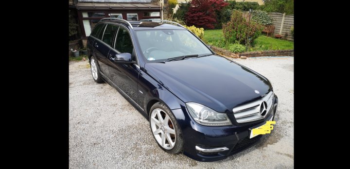 C63 Estate - the "sensible" family car - Page 6 - Readers' Cars - PistonHeads - The image is a photograph of a dark-colored Mercedes-Benz vehicle parked outdoors. It appears to be an SUV model, with the distinctive emblem on the grille and alloy wheels visible. The vehicle is parked on a driveway or in front of a house, as suggested by the residential background. There are no people or additional objects in the immediate vicinity of the car, focusing attention solely on the vehicle itself.