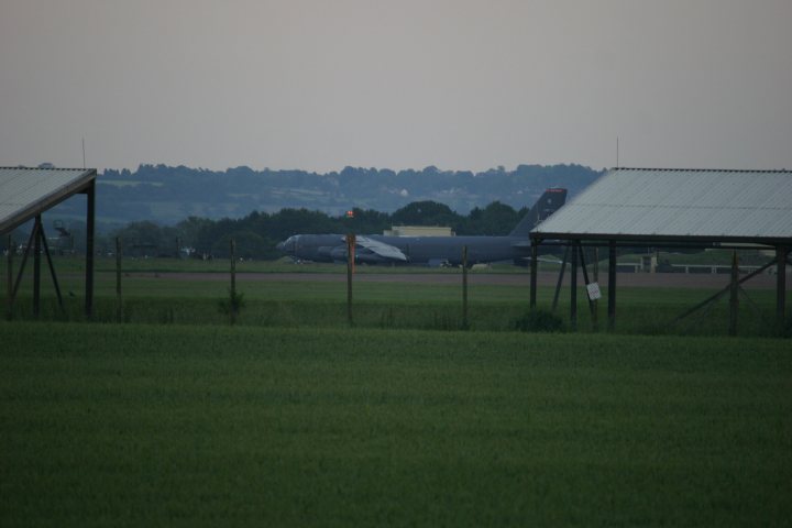 A small plane sitting on top of an airport runway - Pistonheads - The image captures a serene early morning scene at an airport. Dominating the scene is a military airplane standing on the concrete pavement, its presence adding a sense of anticipation and power. The airplane is a stark contrast to the green grass and the few utility buildings in the area, and it seems to be taking a moment of respite in the quietness of dawn. The overcast sky looms in the background, adding a feeling of tranquility to the scene.