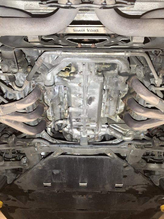 The 997 Appreciation Thread - Page 53 - 911/Carrera GT - PistonHeads UK - The image shows the undercarriage of a car, with various engine components visible. The engine appears to be a V6 configuration, featuring multiple valve covers and intake manifolds. There are no people or other objects in this particular view. The photo seems to have been taken from an overhead perspective, possibly for inspection or repair purposes.