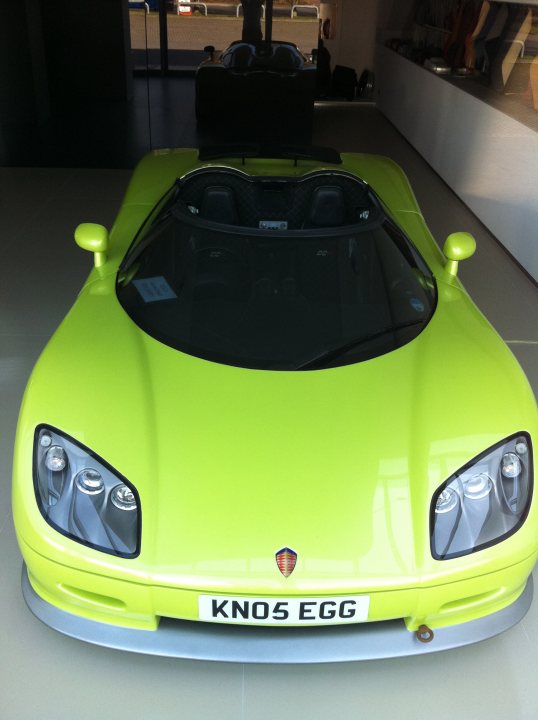 Koenigsegg on display in Exeter - Page 1 - South West - PistonHeads - The image showcases a vibrant yellow Lamborghini sports car that is elegantly positioned in a well-lit room. The vehicle is set against a backdrop that appears to be a display area. The Lamborghini's roof seats are discernible, indicating a convertible model. The exterior of the car is gleaming, suggesting it is well-maintained, and a model badge is prominently displayed on the front of the vehicle.