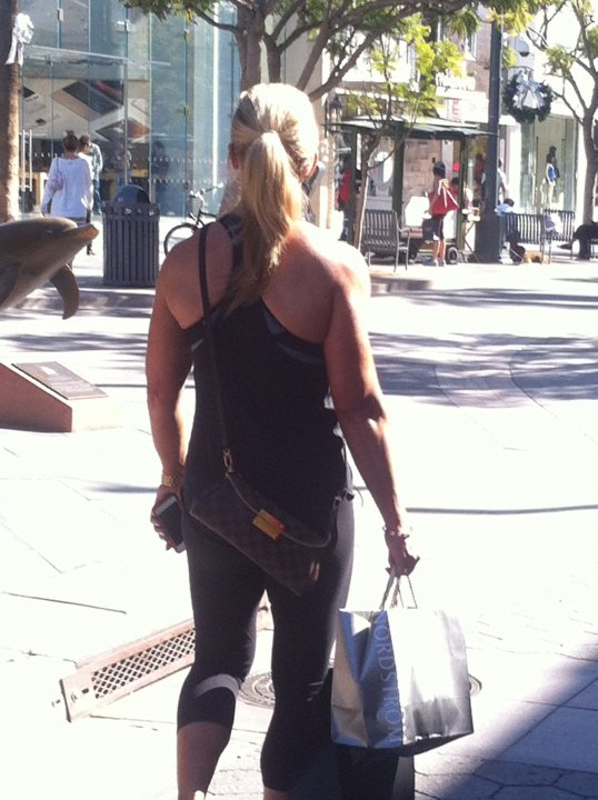 A woman walking down the street with a suitcase