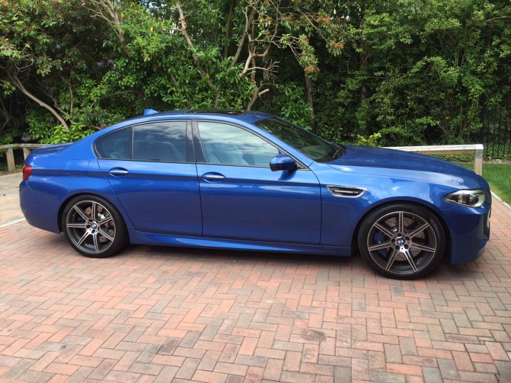 Post your new car here - Page 45 - South Coast - PistonHeads - The image showcases a vibrant blue BMW coupe parked on a brick driveway. The BMW features a sleek design with a set of black five-spoke alloy wheels that add to its sporty appeal. The car is captured from the side, facing the viewer's right, with its trunk door closed. The driveway is situated in a landscaped area with lush foliage in the background, providing a tranquil setting for the vehicle.