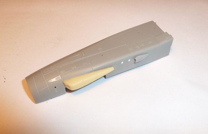 A close up of a nintendo wii remote - Pistonheads - The image features a solitary grey model train car resting on a stark white surface. The train car, with its pointed end, is static, not in motion. It's a close-up shot, providing a detailed take on the object. The minimalistic background enhances the focus on the model train car, highlighting its intricate details.