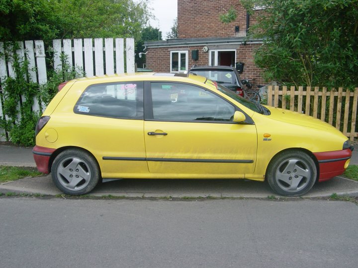 A yellow car parked next to a parking meter - Pistonheads