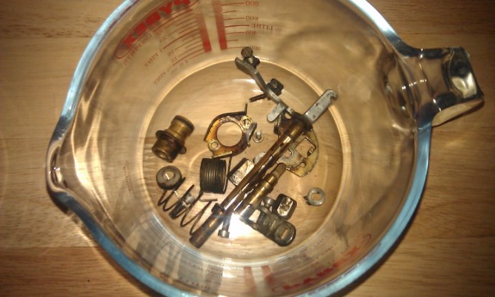 A close up of a urinal on a wall - Pistonheads - The image shows a glass measuring cup containing various mechanical parts. The metal parts appear to be broken, with some visible clips, rings, and a cylindrical object that seems to be a part from some sort of engine or mechanical assembly. The multitude of instructions on the measuring cup's interior indicates a setting involving precision measurement. The cup is placed on a wooden surface, suggesting a home or workshop environment. The perspective is an overhead view, allowing for a comprehensive view of the contents within the measuring cup.