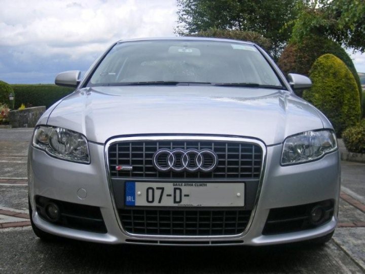 Ireland Sline Tdi Pistonheads - The image is a photograph of a car, specifically a silver Audi. The car is parked outdoors, with the front of the vehicle facing the camera. The Audi has a distinctive grille design and the number plate of the car reads "07-D." The sun is shining in the background, creating a bright contrast with the car's metallic finish. The setting appears to be a residential area, with a clear sky and a partial view of trees or bushes in the background.