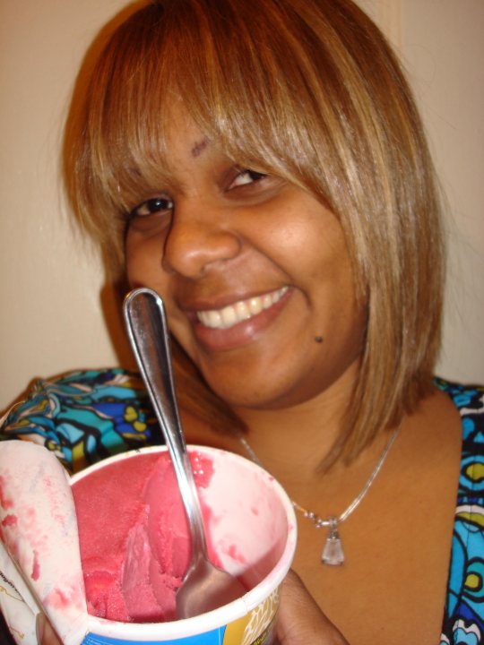 Ice Paper Chain Lady Cream Spoon Tissue - In the image, a woman with short blonde hair is holding a bowl of pink ice cream. She is smiling and looking directly at the camera, suggesting she is in a cheerful or happy mood. The ice cream appears to have Hawaii Honey vendor markings, hinting at the possibility of the flavor being from Hawaii Honey. The woman is wearing a blue and greenish top, which complements the colors of the ice cream. The backdrop is not clearly visible but seems to be a plain wall, which does not distract from the main subject of the image.