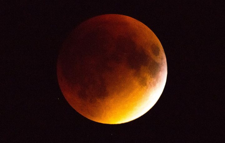 Pistonheads - The image captures a waxing crescent moon, bathed in a deep orange hue. The moon takes center stage against a stark dark sky. The edges and dark areas inside the moon provide intriguing contrast to its illuminated surface. The art style suggests this is an approximation rather than a realistic portrayal.