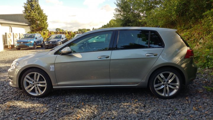 VW Golf 1.4 TSi 150 ps vs. 125 ps - Page 2 - Audi, VW, Seat & Skoda - PistonHeads - The image shows a silver hatchback parked on what appears to be a gravel driveway. There are several other cars visible in the background, which indicates that this is a residential area. The sky is visible in the background, suggesting that the photo was taken during the day. The car's position is perpendicular to the viewer, offering a side view of the vehicle. There are no visible texts or distinctive marks that would provide any additional context about the car or the location.