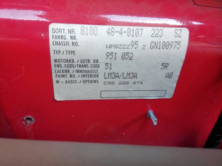 A sign that is on the side of a building - Pistonheads - The image shows a tag attached to a red motorcycle part. The part is identified by the term "Fahrg. NR." which translates to "Driving and hardware." The upper left corner has the text "SORT. NR. 8100 48-48-8107 220 S22." Below this, in a rectangular grid, there is information pertaining to the automotive part. Notable details include makes and models, engine codes and specifications, paint codes, and part numbers. The tags provide details necessary for correctly fitting this motorcycle part to the vehicle. The text on the label is small and appears to be manufacturer specifications.