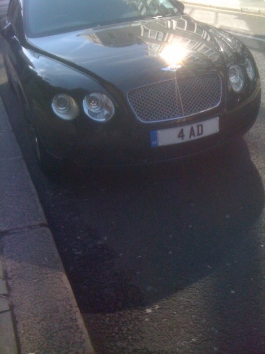 Real Plates Vol Pistonheads - The image captures a scene on the street. At the center of the image is a luxurious black Jaguar car. The car is parked on a street, adjacent to a sidewalk, and directly in front of a fire hydrant. The car displays a 4 AD license plate. The setting appears to be in an urban environment, with the car occupying a sizeable portion of the frame, emphasizing its sleek design and prestigious brand.