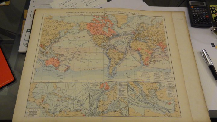 Something different...1895 Times Atlas of the World - Page 1 - Books and Literature - PistonHeads - The image showcases a large, open map of China resting on a cluttered desk. The map is intricately detailed, highlighting the country's geography and the major provinces. Various pens and papers are scattered around it, suggesting that the desk might serve as a workspace or study area. The surroundings include a digital temperature meter, a calculator, and a red folder, hinting at an individual working in a multi-purpose environment.