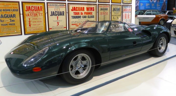 Pistonheads - The image showcases a striking, green sports car on display at an exhibition. The car is positioned in front of a backdrop featuring vintage advertisements and signs, creating a nostalgic atmosphere. It's parked inside a spacious room or hall, suggesting it's part of a larger event. The vehicle itself is sleek and well-maintained, indicative of its status as an exotic sports car. The overall scene suggests a gathering or exhibition focused on automobiles or luxury items.