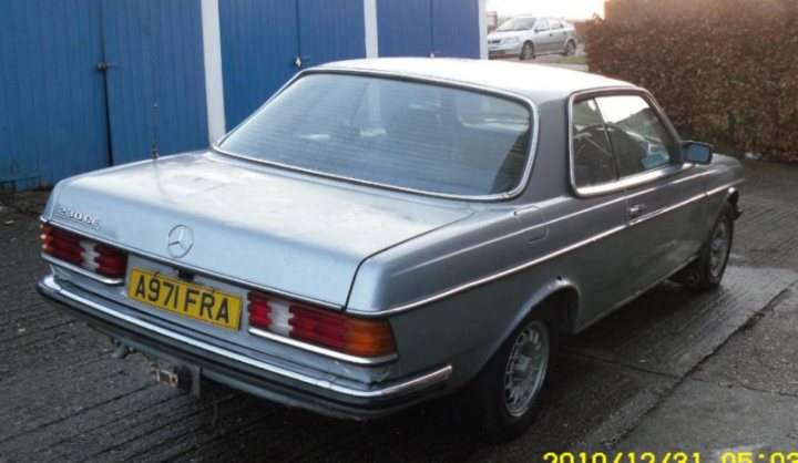 Pistonheads - The image shows a silver car parked on the side of a street, facing towards the right side of the photo. The car is a small, two-door vehicle, possibly a vintage model, with distinctive features like a prominent Mercedes-Benz emblem on the hood and round taillights. The license plate on the car reads "A97 Fra," indicating that the car is likely registered in France. The setting appears to be a quiet suburban or residential area, with a fence visible next to the car, and a partly cloudy sky above.