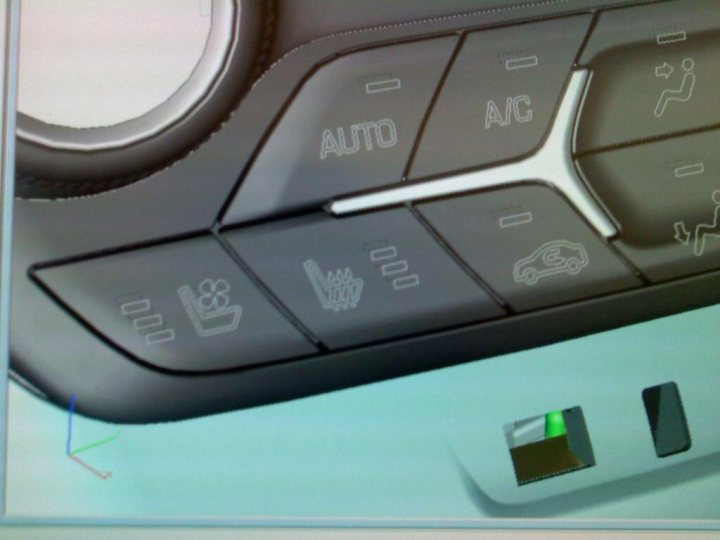 A close up of a keyboard and a mouse - Pistonheads - The image presents a close-up view of a car's center console, focusing on the center console buttons. The buttons, with labels such as "AC," "AUTO," "MD," and "TWEET," suggest they control various functions of the car, including air conditioning, automatic temperature control, multimedia devices, and the tweet function. A smartphone plugged into the car's USB port is also visible in the lower part of the image, indicating connectivity features. The overall aesthetic of the dashboard combines silver and black colors with a sleek design.