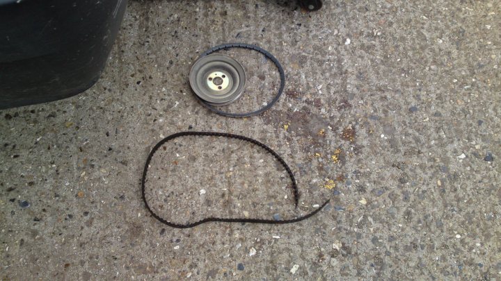 Pistonheads - The image captures a single rubber tire on a concrete surface, discarded seemingly hastily. The tire appears to belong to a vehicle, and is marked with a single bolt and rim on both the left and right sides. Accompanying the tire are various pieces of its broken components, including rubber melt and rusted metal fragments scattered across the concrete. The scene is one of abandonment and neglect.