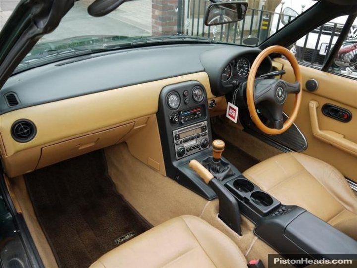 A close up of a luggage bag on a car - Pistonheads - The image showcases the interior of a classic Mercedes-Benz convertible, seemingly a Pagoda from the 1960s. The tan seat contrasts with the black steering wheel and console. The center console sets the stage for multiple switches, indicative of the convertible's extensive features. Despite its age, the car exudes a sense of luxury and style, encapsulating the appeal of vintage automobiles.