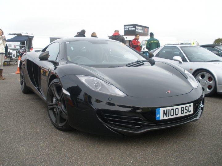 Thank you. - Page 1 - East Anglia - PistonHeads - In the photo, a black Aston Martin Rapide sports car is parked on an asphalt road in a lot. The car has a striking design with a long hood and a wide, low stance. The license plate is visible and reads "M10 BSC". It appears to be a sunny day as indicated by the shadows on the ground. Other cars are parked nearby, and a few people are walking around, giving a sense of scale.