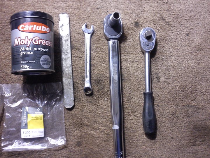 A pair of scissors sitting on top of a table - Pistonheads - The image shows a variety of auto parts laid out on a cluttered surface. There is a tube of grease labeled "Carbule Multi-Purpose Grease" which indicates it's designed for use on various components. In front of it, there's a broken flat head screwdriver, a hex wrench, and another wrench, suggesting mechanical work is being done. Next to these tools, there's a loosened bolt cap and a wheel chock, often used to prevent a vehicle from rolling. The setting appears to be a makeshift workshop or garage, with the focus on the task at hand. The presence of grease and the tools imply some form of vehicle maintenance or repair work. The image does not show a person or specific location, but rather a collection of items used for automotive purposes.