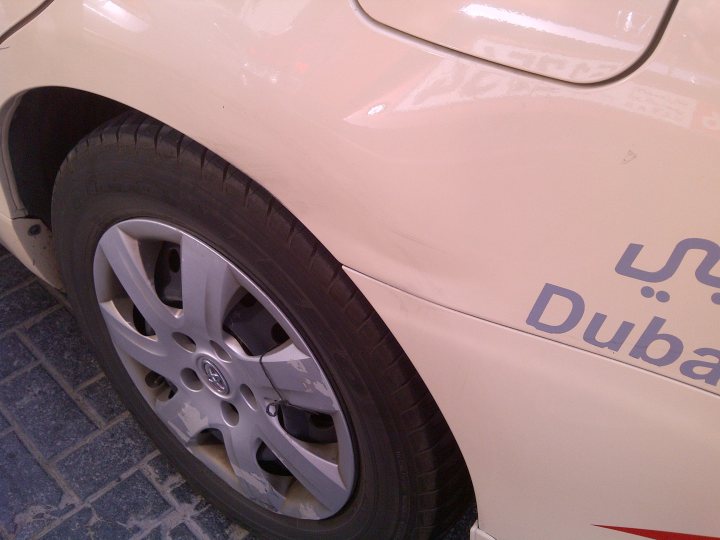 Pistonheads - The image depicts the wheel and front fender of a car. The car appears to be a light color, possibly white or beige, and the wheel is black with silver highlights, possibly from reflections of light. On the car body, there is a distinct logo that appears to be a mirrored 'dub'. This could suggest that the car is a Dubai Dubai Limited vehicle, which is a part of the Nissan brand. The angle of the photo indicates it was taken while the car was stationary, and the image does not provide any information about the vehicle's surroundings or the operational condition of the car.