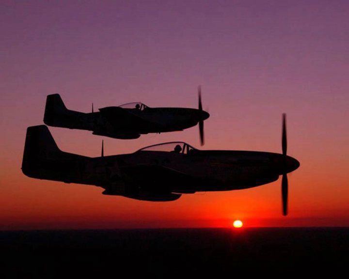 Post amazingly cool pictures of aircraft (Volume 2) - Page 203 - Boats, Planes & Trains - PistonHeads - The image shows two vintage-style fighter jets soaring in a clear sky at either dawn or dusk, given the warm hues of the low sun. A hint of orange on the horizon signifies the time, adding a dramatic effect to the scene. The silhouettes of the fighter planes and their propellers are sharply contrasted against the sky, emphasizing flight and jet propulsion. The strong framing of the image suggests it was taken from an elevated position, like a tower or another plane, lending a perspective that enhances the sense of motion and adventure.