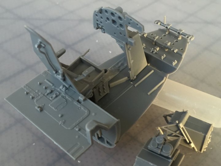 Tamiya 1/32nd Mosquito FBIV - build! - Page 1 - Scale Models - PistonHeads - This image features a close-up view of two model plane components: a fuselage and a landing gear. The fuselage is gray and detailed, while the landing gear appears to be comprised of smaller parts like wheels and possibly additional components. The parts are shown against a neutral background, highlighting their design and texture. The style of the image appears to be a product photograph, possibly for a hobbyists' kit, aimed at showcasing the intricate details of the model aircraft parts.