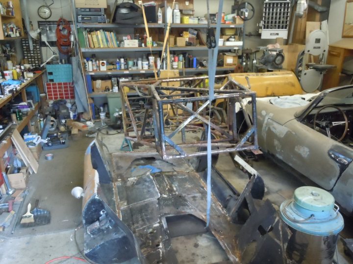 A bunch of luggage that are sitting on a conveyor belt - Pistonheads - This image depicts an indoor environment, likely a garage or workshop, where there are various old pieces of machinery and equipment scattered around. The focal point of the image is a broken prototype car with its body cracked open, revealing its interior components. There are several shelves laden with assorted tools, vehicles parts, and other items, suggesting a workspace for repairing or modifying vehicles. The background appears cluttered and somewhat disorganized, with various objects piled up and strewn about, indicating a heavy focus on work and creativity, rather than presentation or cleanliness. The atmosphere seems to reflect a DIY ethos, with every visible object purposefully placed or utilized.