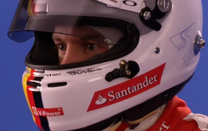 A young boy wearing a helmet and goggles - Pistonheads - The image captures a close-up view of a person wearing a protective racing helmet. The helmet is predominantly white and features several logos and designs, including the Santander logo. A black visor shields the wearer's eyes, giving a sense of anticipation or focus. The person's gaze is directed slightly off-frame, possibly indicating their attention is elsewhere; the rest of their racing attire is not visible in the frame.