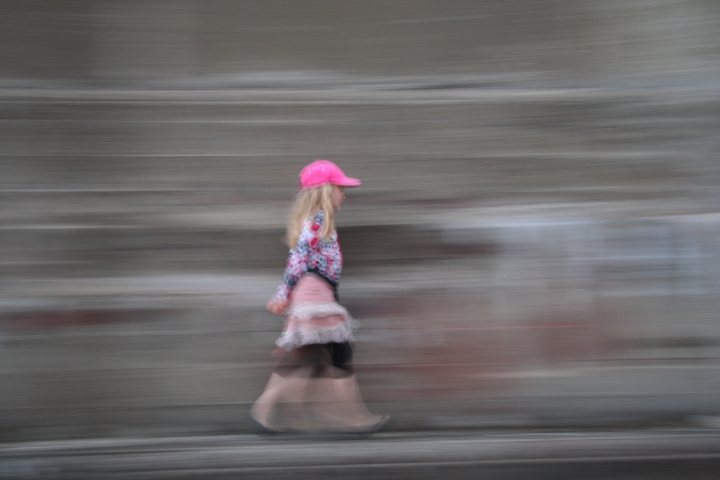 A woman walking down a street holding an umbrella - Pistonheads