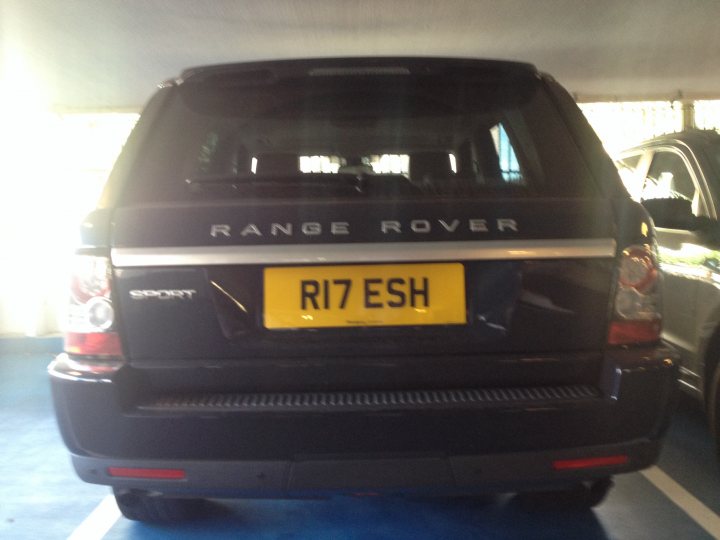 Real Good Number Plates : Vol 4 - Page 213 - General Gassing - PistonHeads - The image shows the back of a Range Rover, a luxury SUV, parked in a covered parking area. The vehicle is black and has a yellow license plate that reads "R17 ESH." The license plate is affixed to the back of the car just above the taillights, which are white and red lights visible on the left side of the vehicle. The parking lot appears to be outdoors, using a shade covering for parking. The area behind the car is not clearly visible due to the shade and the cropping of the photo.