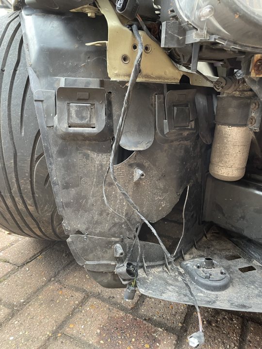 A close up of a fire hydrant on a city street - Pistonheads - The image shows a vehicle, specifically the underside of its rear bumper area. There is significant damage to the bumper, which has been partially removed or ripped away from the rest of the car. Exposed underneath are various mechanical components, such as an exhaust system and what appears to be part of the suspension or chassis. There's also a visible hose connected to something in the vehicle. The car is parked on a driveway with what seems like a brick wall behind it. The overall scene suggests that the vehicle has been involved in a collision or some other type of accident, resulting in the damage visible in the image.