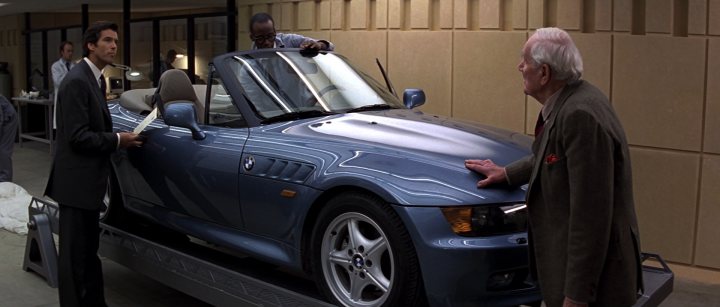 Your favourite car from the year you were born in... - Page 6 - General Gassing - PistonHeads - The image shows a scene with two men standing next to a blue, convertible sports car. The car appears new and well-maintained, with a sleek and shiny finish. One man is holding a clipboard, suggesting he might be studying the vehicle in depth or ready to review it. The second man is looking at the menus, as seen from a paper in his hand. They are dressed in business attire, implying a formal setting. In the background, there is another person and a suitcase, possibly indicating a workspace or waiting area. Overall, the scene suggests a professional interaction with the car, possibly related to a sales, appraisal, or presentation event. The menus' presence hints at a written, orderly process involving the car's details. The setting seems professional, possibly in a showroom, dealership, or similar venue.