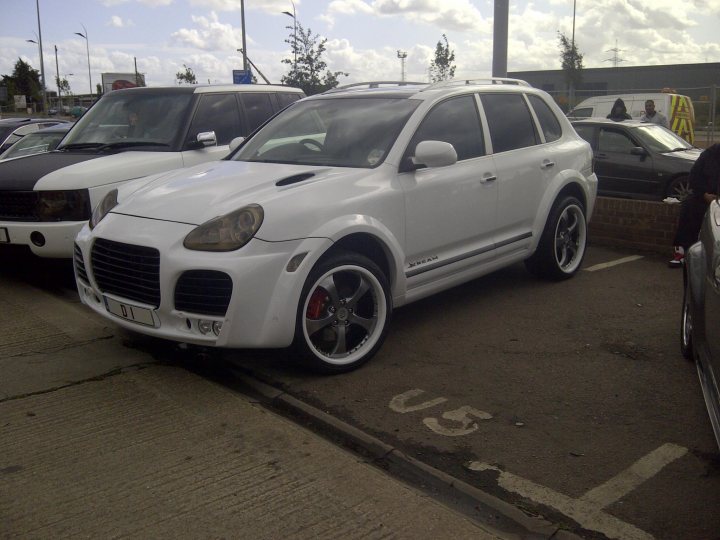 Get your car rated! - Page 106 - Readers' Cars - PistonHeads - The image showcases a white SUV parked in an underground parking lot. The vehicle is a four-door SUV, with its black roof racks giving it a sporty look. The SUV features a prominent grille and sleek design, indicative of modern car design. It is parked adjacent to a No. 55 space, as indicated by the white painted lines on the ground. A few rows of parking spots are visible in the background, some of which are occupied by other vehicles.