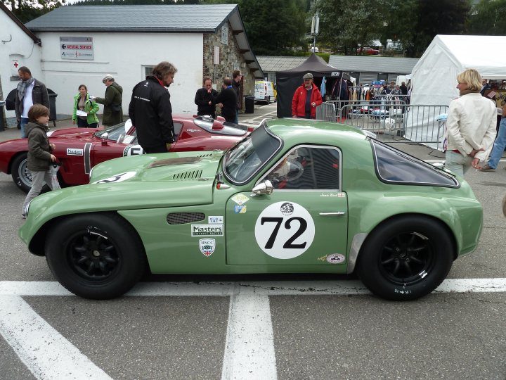 Spa 6 hours, 2015 - Page 1 - Classics - PistonHeads - In the image, we see a scene from a vintage car show. The main focus is a vibrant green Porsche 72, prominently parked on the street. A crowd of people, dressed in casual attire, are gathered around the car, examining its features and the sign reading "72" on the hood. The backdrop features more vintage cars and buildings, enhancing the vintage ambiance of the event. The lively atmosphere suggests a shared interest in classic cars.