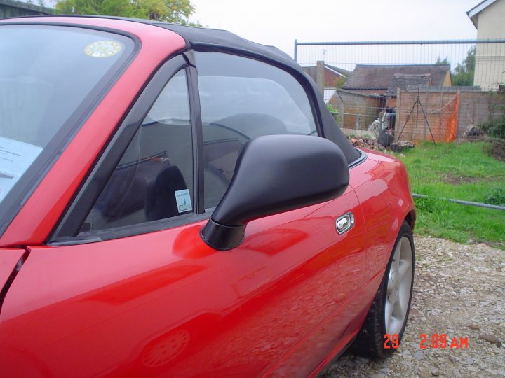 Reg Diagram Mirror Wing Mitsubishi Wireing Pistonheads Charisma - The image shows the interior of the driver's side door on a red sports car parked outdoors. Through the car's window, you can see a part of the side mirror. The car is parked on a gravel or rocky surface, adjacent to a small clearing with greenery and an orange construction fence in the background. The timestamp in the image's lower right corner indicates the date and time as March 29, 2023, at 2:04 AM. The car's design and color suggest it may be a modern, high-performance vehicle.