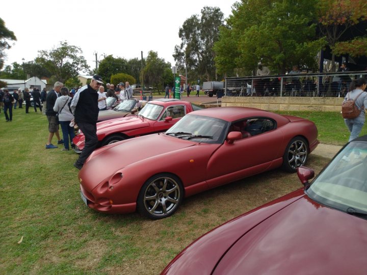 My Cerbera repair/engine rebuild etc. - Page 1 - Cerbera - PistonHeads UK - The image depicts a lively scene at an outdoor car show. Several red sports cars are on display, showcasing their sleek designs and polished finishes. These cars are the stars of the event, drawing attention with their vibrant color.

The setting is a spacious parking lot filled with spectators, who are observing the vehicles up close. Some individuals appear to be discussing the features of the cars, while others seem to be simply admiring them. The atmosphere is energetic and bustling, typical of such events.

In the background, there's a lush green field under a partly cloudy sky, providing a serene contrast to the excitement in the foreground. The event seems to have been well-organized, with ample space for both the cars and the attendees.