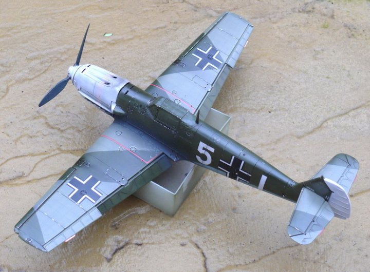 Latest Project: Matchbox 1/32 Bf-109E-3 - Page 16 - Scale Models - PistonHeads - The image depicts a detailed model of a vintage military aircraft, specifically from World War II, given away by its distinct paint scheme and markings. It appears to be a French propeller plane, as indicated by the text "5" and a partial text that reads "FR". The aircraft is positioned with its nose pitched downward to the left, as if performing a trick or maneuver. The model is rendered in a combination of grey and blue, with white for the numbers, evoking the original color palette of the vehicle. The model is meticulously crafted, showcasing the wings, fuselage, propeller, and landing gear in three-dimensional detail, reflecting the technological advancements in aerial warfare during the WWII era.
