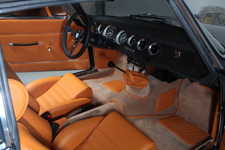 RE: This Alfaholics GTA-R 300 has a carbon body... - Page 1 - General Gassing - PistonHeads - The image shows an interior view of a vintage or classic car, likely from the 1960s or 1970s given its design. The vehicle features tan leather upholstery with the seats removed to reveal the padding underneath. The door panels are open, providing a clear sight of the interior. In the background, there is a steering wheel on the right side, which indicates the car's driver's seat. There are also elements suggesting a sunroof and other vehicle details that are typical of classic cars from that era.